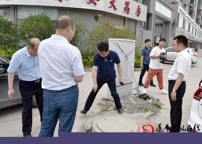 上圖:縣委副書記尹永彪與相關部門負責人在城南建材市場西南角查看電纜井,研究解決辦法。