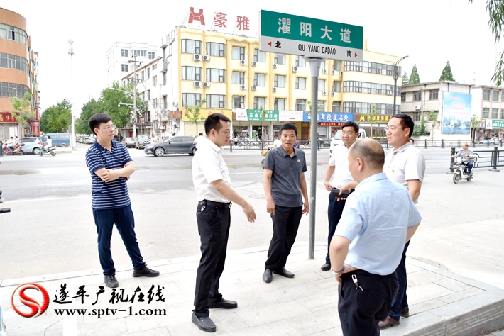 上圖:縣委副書記尹永彪與相關部門負責人在水果市場東南角查看人行道的鋪設情況。