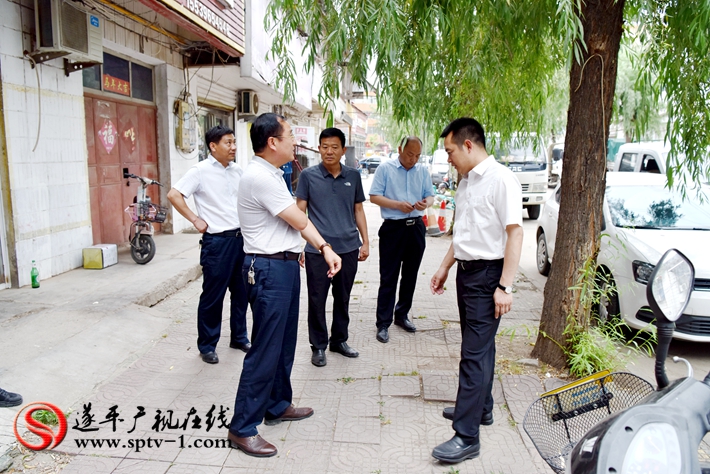 上圖:縣委副書記尹永彪與相關部門負責人在民安西路查看面磚破損情況,并責成城管局盡快修復。