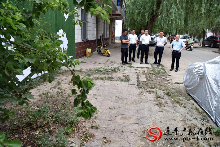 上圖:縣委副書記尹永彪與相關部門負責人在民安西路查看面磚破損情況,并責成城管局盡快修復。